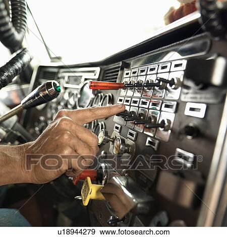 Interior of mid-adult Caucasian male hand pressing switch on dashboard of a tractor trailer. View Large Photo Image Stock Photo - Interior of mid-adult Caucasian male hand pressing switch on dashboard of a tractor trailer.. Fotosearch