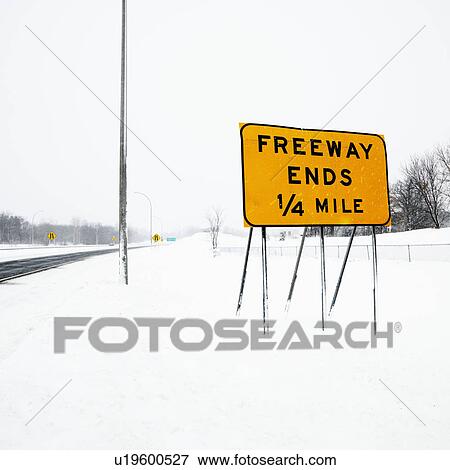 Stock Photo - Snow covered highway with sign reading Freeway ends quarter mile.. Fotosearch