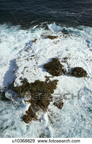 Aerial view of rocks in Pacific ocean with water swirling around them off the coast of Maui, Hawaii View Large Photo Image Stock Photo - Aerial view of rocks in Pacific ocean with water swirling around them off the coast of Maui, Hawaii. Fotosearch