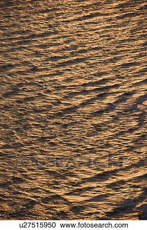 Stock Image - Rippled Atlantic ocean water with sun reflection. Fotosearch