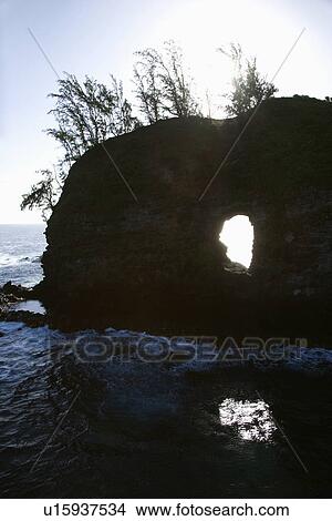 Rock with hole in it in Pacific ocean off island of Maui, Hawaii View Large Photo Image Picture - Rock with hole in it in Pacific ocean off island of Maui, Hawaii. Fotosearch