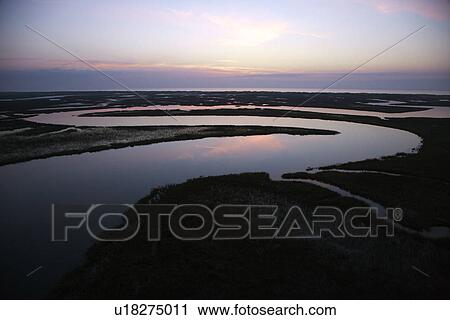 Stock Image - Tidal creek meandering through wetlands of Bald Head Island, North Carolina. Fotosearch