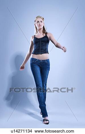Picture - Blue toned full length studio portrait of pretty blonde Caucasian young woman.. Fotosearch