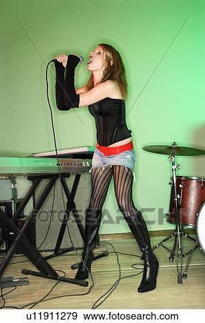 Female singing into microphone View Large Photo Image Stock Photo - Female singing into microphone. Fotosearch