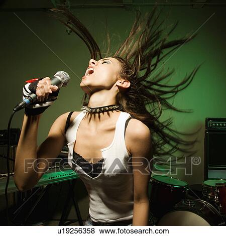 Female swinging head and hair while singing into microphone View Large Photo Image Stock Photo - Female swinging head and hair while singing into microphone. Fotosearch