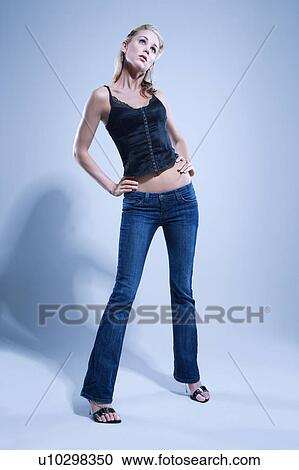 Stock Image - Full length studio portrait of young woman.. Fotosearch