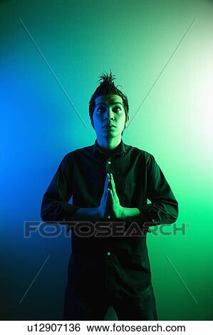 Man standing holding hands in prayer position View Large Photo Image Stock Photograph - Man standing holding hands in prayer position. Fotosearch