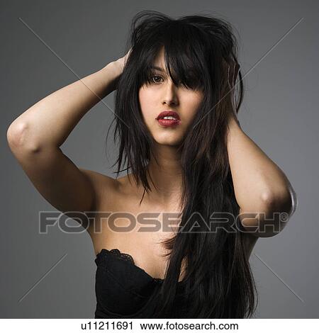 Stock Image - Portrait of pretty young woman with long black hair.. Fotosearch
