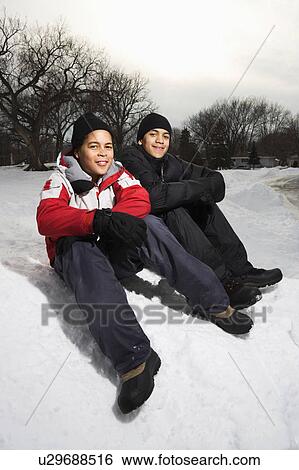 Stock Photograph - Boys sitting in snow . Fotosearch