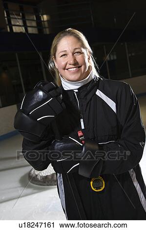 Stock Image - Female hockey coach in uniform standing smiling.. Fotosearch
