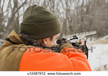 Male aiming shotgun out towards woods View Large Photo Image Stock Image - Male aiming shotgun out towards woods. Fotosearch