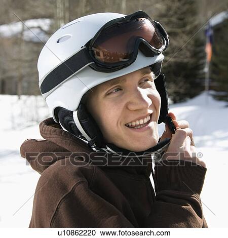 Male teenager fastening helmet View Large Photo Image Stock Image - Male teenager fastening helmet. Fotosearch