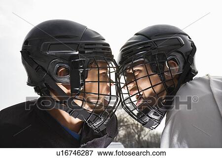 Stock Photo - Two ice hockey players in uniform facing off trying to intimidate eachother.. Fotosearch