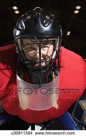 Woman hockey goalie wearing helmet sneering looking intimidating. View Large Photo Image Picture - Woman hockey goalie wearing helmet sneering looking intimidating.. Fotosearch