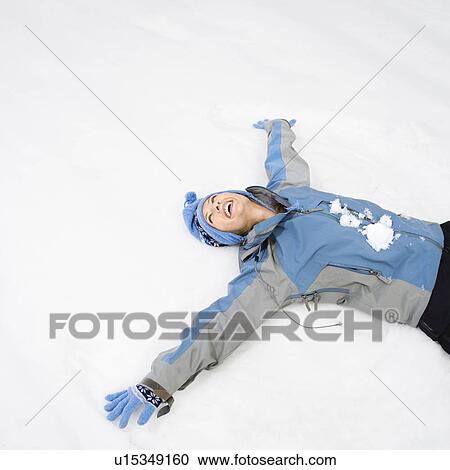 Stock Image - Woman making snow angel. Fotosearch