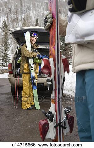 Stock Photograph - Couple standing with ski equipment . Fotosearch