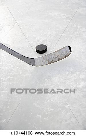 Stock Photo - Hockey stick on ice rink to hit puck. Fotosearch