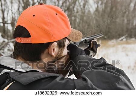 Male aiming shotgun towards woods View Large Photo Image Stock Photograph - Male aiming shotgun towards woods. Fotosearch