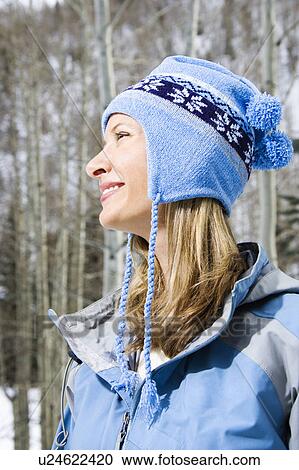 Stock Image - Side view head and shoulder of attractive smiling mid adult blond woman wearing blue ski clothing. Fotosearch