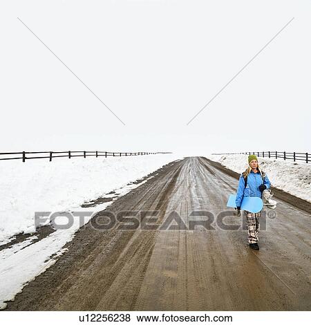 Walking alone holding snowboard and boots View Large Photo Image Stock Photo - Walking alone holding snowboard and boots. Fotosearch