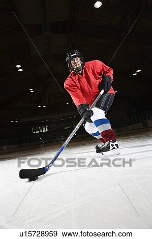 Woman hockey player skating on ice lining up to shoot puck View Large Photo Image Stock Photo - Woman hockey player skating on ice lining up to shoot puck. Fotosearch