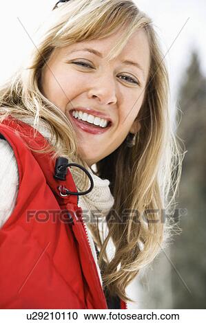 Stock Image - Woman wearing red ski vest. Fotosearch