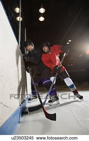 Stock Photography - Women hockey players fighting for puck making contact. Fotosearch