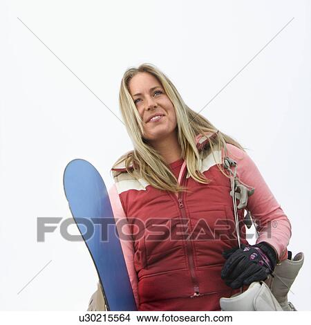 Young woman holding snowboard and boots. View Large Photo Image Picture - Young woman holding snowboard and boots.. Fotosearch