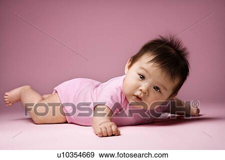 Baby lying on stomach holding arms out to side View Large Photo Image Stock Photo - Baby lying on stomach holding arms out to side. Fotosearch