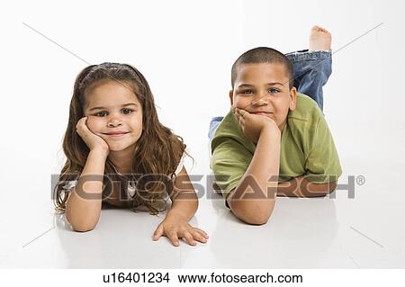 Picture - Brother and sister lying on floor. Fotosearch