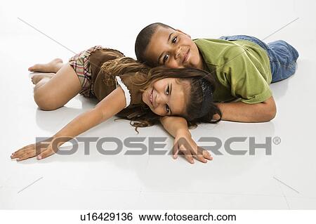 Stock Photograph - Brother and sister lying on floor . Fotosearch