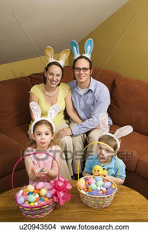Picture - Caucasian family wearing rabbit ears with Easter baskets looking at viewer. . Fotosearch