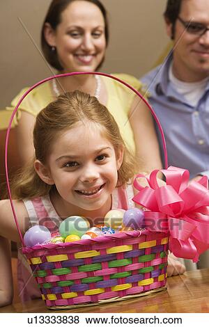 Stock Photo - Caucasian family with girl and Easter basket. . Fotosearch