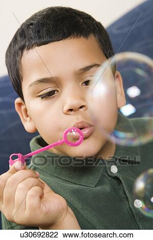 Hispanic boy blowing large soap bubbles. View Large Photo Image Stock Image - Hispanic boy blowing large soap bubbles.. Fotosearch