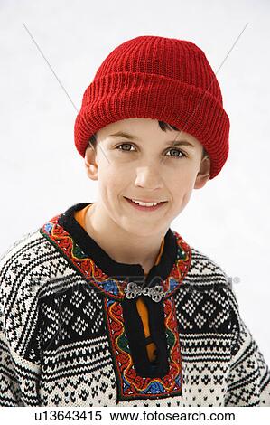 Stock Photography - Portrait of boy wearing sweater and red winter cap. Fotosearch