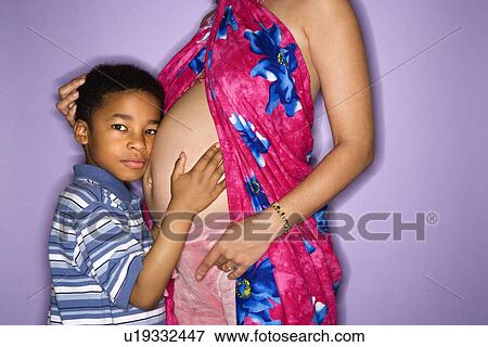 Portrait of expecting female with son listening to stomach. View Large Photo Image Stock Photo - Portrait of expecting female with son listening to stomach.. Fotosearch
