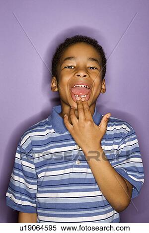 Portrait of young boy looking at viewer and showing where his tooth fell out. View Large Photo Image Stock Photography - Portrait of young boy looking at viewer and showing where his tooth fell out.. Fotosearch