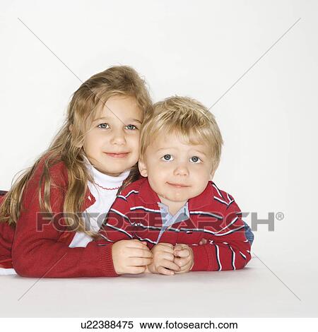 Stock Photography - Studio portrait of Caucasian boy and girl against white background.. Fotosearch