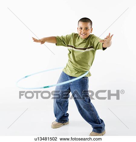 Stock Image - Young latino adolescent boy using hula hoop.. Fotosearch