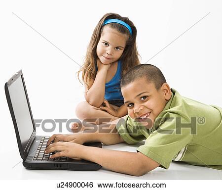Stock Photograph - Young latino boy using laptop computer while girl watches.. Fotosearch