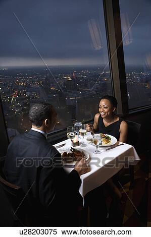 Stock Photography - Couple having dinner near a window with a view. Fotosearch