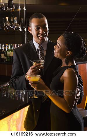 Couple having drinks at the bar View Large Photo Image Stock Photograph - Couple having drinks at the bar. Fotosearch