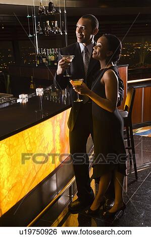 Couple having drinks at the bar View Large Photo Image Stock Photograph - Couple having drinks at the bar. Fotosearch