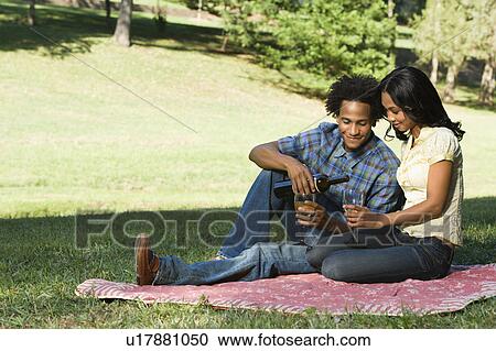 Couple having romantic picnic in park drinking wine View Large Photo Image Stock Image - Couple having romantic picnic in park drinking wine. Fotosearch