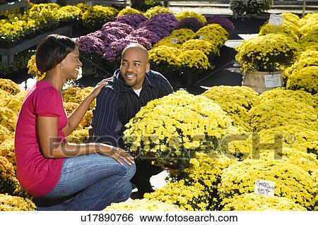 Stock Photograph - Couple picking out fall flowers. Fotosearch