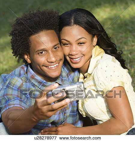 Couple taking pictures in park View Large Photo Image Stock Photo - Couple taking pictures in park . Fotosearch