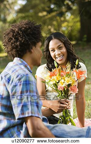 Man giving smiling woman bouquet of flowers. View Large Photo Image Stock Photo - Man giving smiling woman bouquet of flowers.. Fotosearch