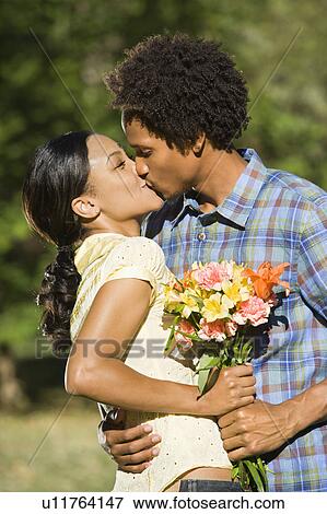 Woman and man embracing and kissing in park. View Large Photo Image Stock Photo - Woman and man embracing and kissing in park.. Fotosearch