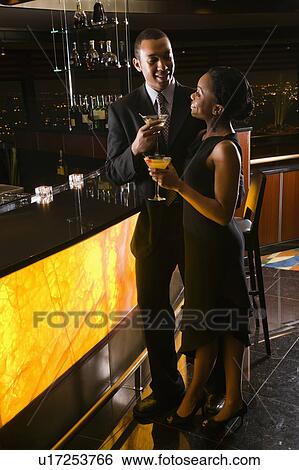 Young couple having drinks at the bar. View Large Photo Image Stock Photograph - Young couple having drinks at the bar.. Fotosearch