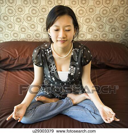 Asian female sitting on bed meditating. View Large Photo Image Stock Photo - Asian female sitting on bed meditating.. Fotosearch